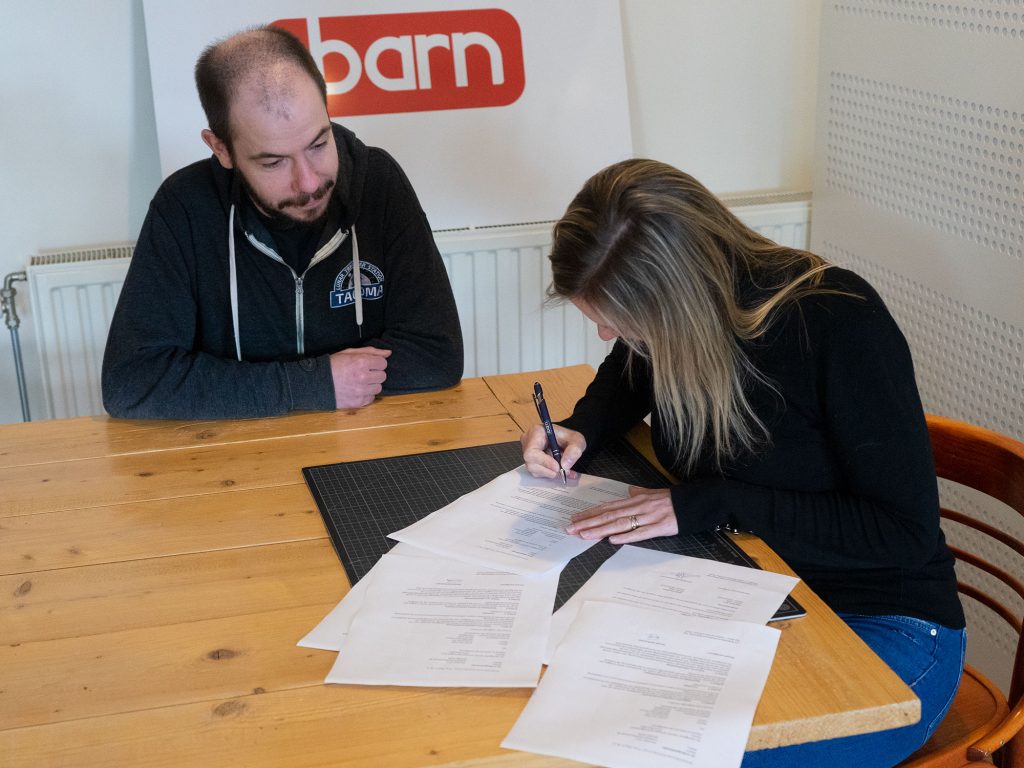 Arne and Linda signing the contract